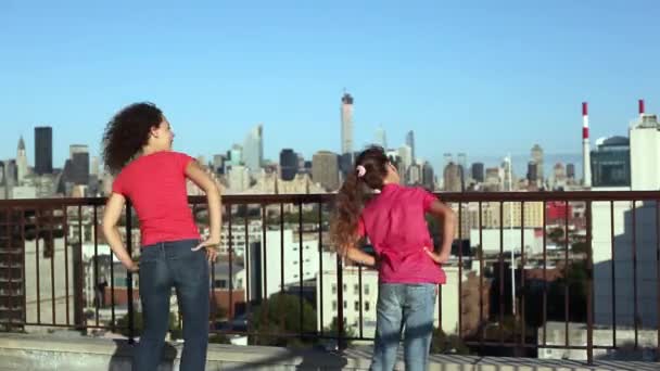 年轻妇女和女孩做边弯曲在屋顶反对蓝色天空 — 图库视频影像
