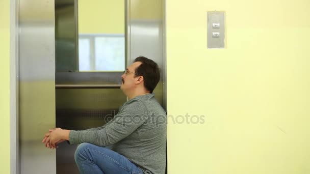 Man Zit Bij Afsluiting Van Lift Het Trappenhuis — Stockvideo