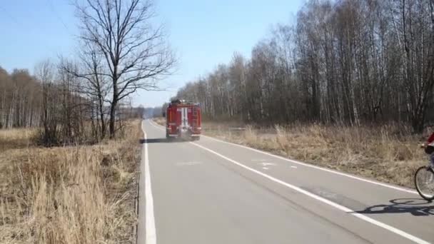 消防車 モスクワの碑文と自転車公園のパス上の女性 — ストック動画