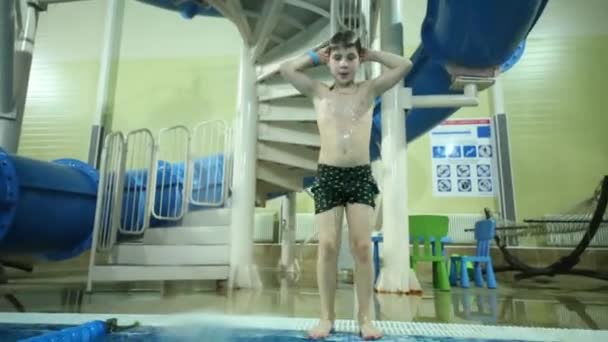 穿短裤的小男孩跳进室内泳池 跌倒了 — 图库视频影像