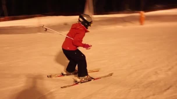 Meisje kind skiër neer op helling in de winternacht — Stockvideo