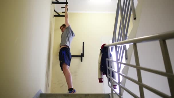 Young Man Trains Horizontal Bar Staircase Building — Stock Video