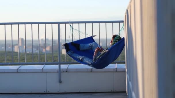 Чоловік Лежить Гамаку Кутку Даху Фотографується Смартфоні — стокове відео
