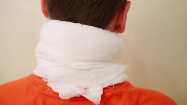 男孩少年用纱布包扎在颈部的房间 — 图库视频影像