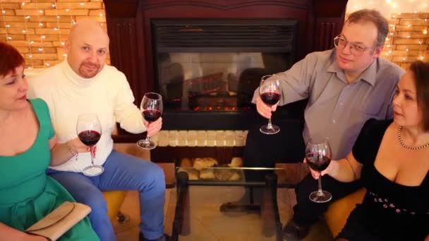Τέσσερις Φίλοι Κόκκινο Κρασί Ποτήρια Επικοινωνούν Δωμάτιο Τζάκι — Αρχείο Βίντεο