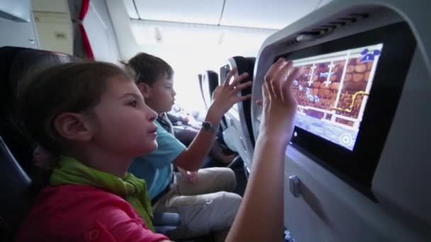 子供が空港シャルル ゴール空港で飛行機の Backseats にマウントされているマルチ メディア モニターでコンピューター ゲームをプレイ フランス 2014 — ストック動画