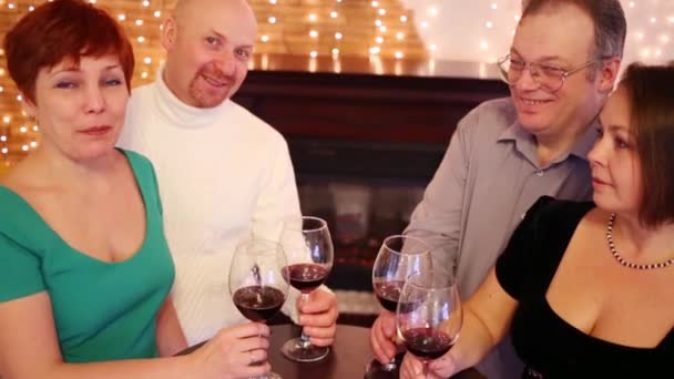 Four Friends Red Wine Glasses Sit Fireplace Smile — Stock Video