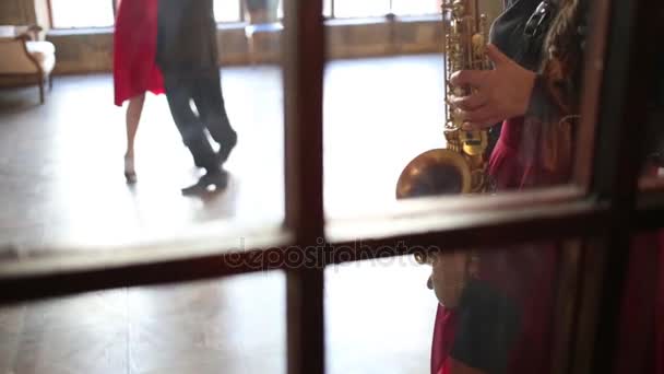 Rapariga Toca Saxofone Casal Dança Atrás Janela Foco Menina — Vídeo de Stock