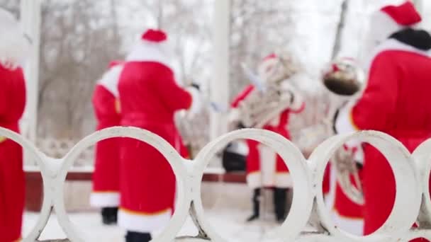 Witte Hek Brass Band Van Kerstmannen Presteert Onscherp Winter Buiten — Stockvideo