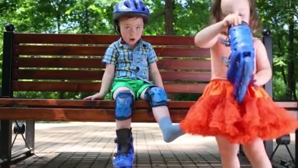 Pequeno Menino Bonito Senta Banco Menina Ajuda Ele Parque — Vídeo de Stock