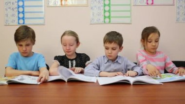 Moskova, Rusya - 28 Nisan 2015: Dört çocuk kitap okumak, kameraya bakıyor