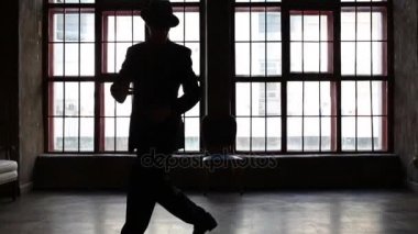Adam siyah takım elbise ve şapka pencere tango dans silüeti