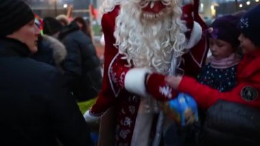 Moskova - 18 Aralık 2014: Ded Moroz çocuklar oyun alanında karmaşık Losinyj Ostrov üzerinde Çikolata kutularını teslim. Rusya, Moskova Kızıl Meydan ana Noel ağacı ayarlanır.
