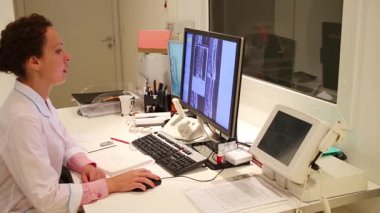 Doktor omurga MRI görüntüleri ekrana görünüyor.