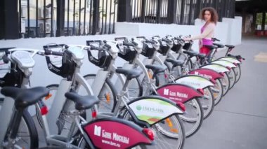 Moskova - 8 Haziran 2015: Kadın sokak Park üzerinde Bisiklet Kiralama satırı seçer. Moskova Hükümeti Avrupa başkentleri takip kentsel Bisiklet Kiralama projesi başlattı.