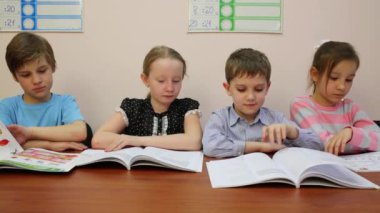 Moskova, Rusya - 28 Nisan 2015: Dört çocuk onların parmak çizgisinde çalıştıran kitap okur