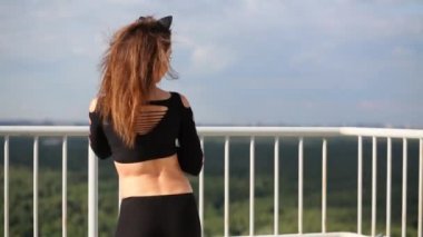 Rüzgarlı bir gün çatıda eskrim yakınındaki kadın kedi siyah kostüm döner