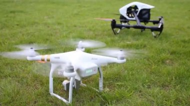 Moskova - 8 Ağustos 2015: Pervane quadrocopters ayakta yeşil çimenlerin üzerinde siyah ile DJI indeks işlem ilham ve beyaz ile DJI indeks işlem Phantom ile açın. Teklik ile DJI indeks işlem - yeni gelişmeler hızlı giriş.