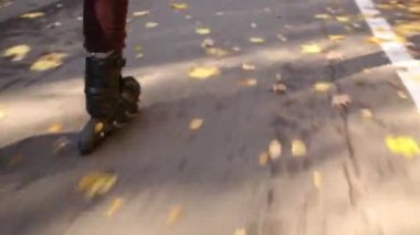 Tekerlekli paten sonbahar ormanda kız bacakları