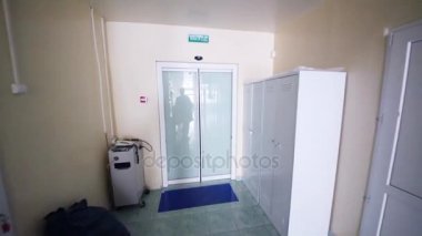 Hastane, insanlar yak²n kapıları ile hareket koridorda. Duvarlarda metin: çıkış, kat