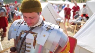 Moskova - 6 Haziran 2015: Adam plaka zırh Kolomenskoye tarihsel Festivali üzerinde çadır ve diğer savaşçılar arasında diyor. Çalışma gelenekleri askeri kültürünün amaçla düzenlenen Festivali.