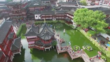 Shanghai - 06 Kasım 2015: Yuyuan Bahçe 9 tarafından yürümek insanlar ile sonbahar gününde eski tarzı binalar arasında gölet üzerinde döner köprü. Havadan görünümü