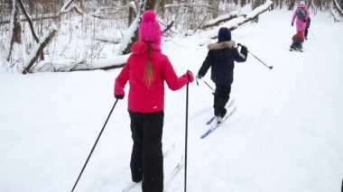 Bir kadın ve dört çocuk ormandaki kızak ile Kayak arkası