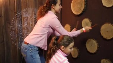 Anne ve kız sopa ve duvar ahşap tekerlekleri ile oynamak