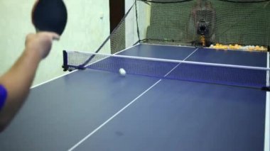 Adam makine Masa Tenisi üzerinde ateş topları yener