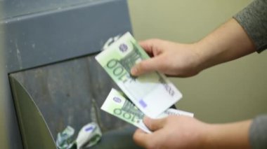 Adam 100 euro Bono ve onları çöp öğütücüye atma crumples