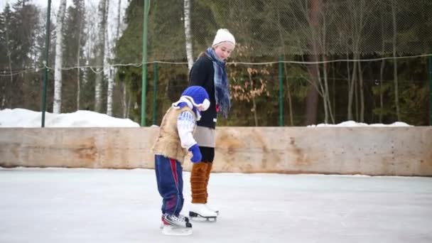 Chica Enseña Hermano Menor Patinar Pista Día Invierno — Vídeo de stock