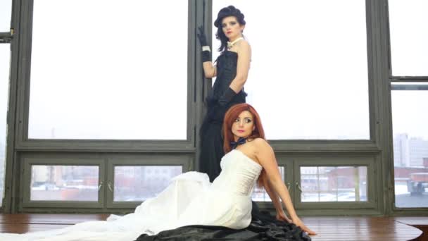 Dwie Piękne Kobiety Czarno Białe Sukienki Stanowią Blisko Okna — Wideo stockowe