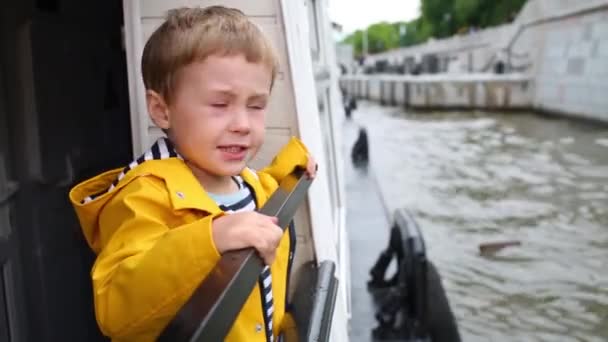 Niño Chaqueta Amarilla Mira Paseo Marítimo Desde Barco — Vídeo de stock