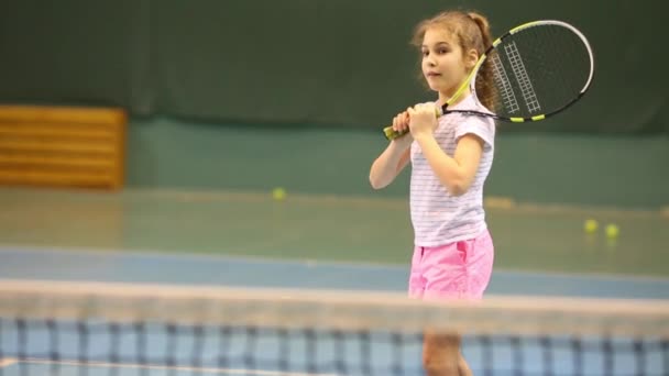 幸せな女の子テニス トレーニング中にネット上のボールを撃退することを学ぶ — ストック動画