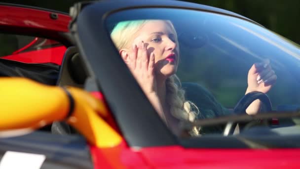 Mulher Loira Carro Esporte Vermelho Olha Espelho Mantém Roda — Vídeo de Stock