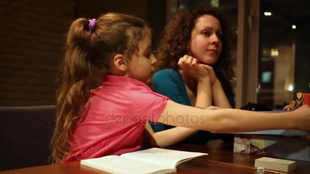 Κορίτσι Που Κάθεται Στο Τραπέζι Βιβλίο Και Κοντά Στη Μητέρα — Αρχείο Βίντεο