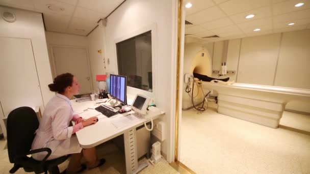Lékař Sedí Stolu Zatímco Pacient Leží Posteli Mri Skeneru — Stock video