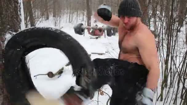 Bare Chested Guy Beats Old Used Tire Attached Pine Trunk — Stock Video