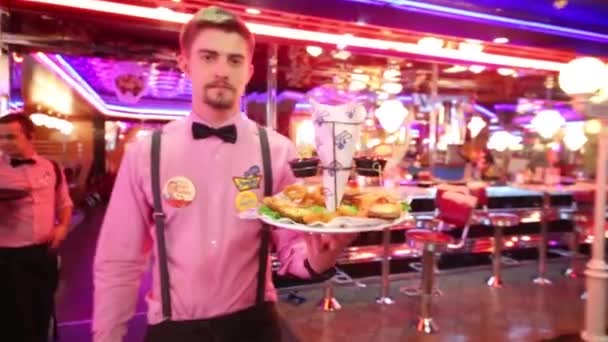 ビバリー ヒルズ ダイナー モスクワで様式化されたアメリカのレストランのネットワークでモスクワ 2015 ウェイター運ぶ皿 皿にフォーカス — ストック動画