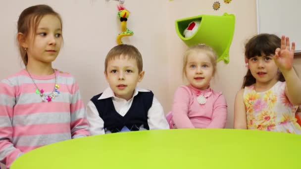 Τέσσερα Παιδιά Που Κάθεται Στο Τραπέζι Και Δείχνει Χειρονομία Στο — Αρχείο Βίντεο