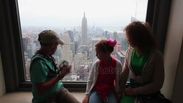 モデルのリリース つの家族がロックフェラー センター岩の観察デッキ上部部屋の窓辺に座るニューヨーク アメリカ合衆国 2014 — ストック動画