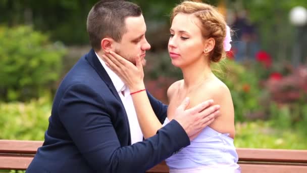 男子和妇女拥抱和亲吻在长凳上公园 — 图库视频影像