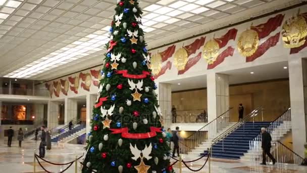 モスクワ 2014 人間の間でクレムリン宮殿の広々 としたホールでクリスマス ツリーが飾られています クレムリン宮殿の建設は続いた — ストック動画