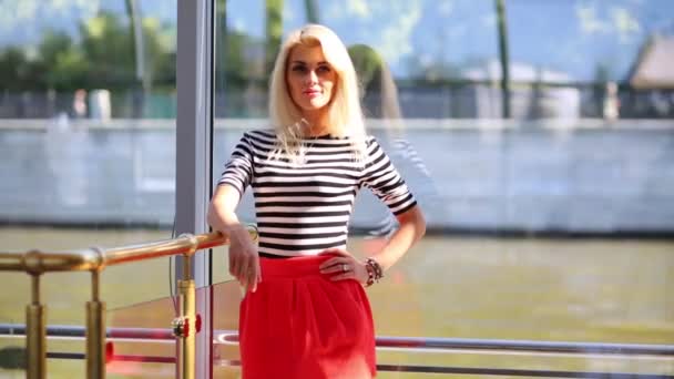 Blondine Singlet Und Rotem Kleid Steht Fenster Des Restaurantschiffes — Stockvideo