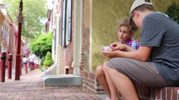 男孩和女孩打牌在最旧的街道在美国 Elfreth 胡同在费城 宾夕法尼亚 — 图库视频影像