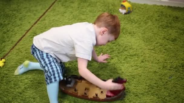 Αγόρι Παίζει Πλαστικό Viking Πλοίο Στον Πράσινο Τάπητα — Αρχείο Βίντεο