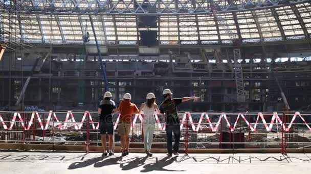 Quatro Pessoas Perto Cerca Olhando Para Reconstrução Estádio — Vídeo de Stock