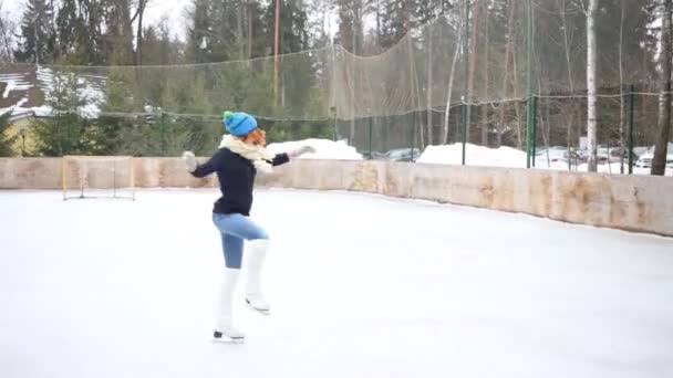 幸せな 代少女の優雅なスケート スケート リンク冬の日でスピン — ストック動画