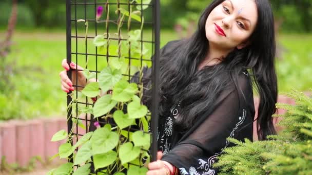 Black Haired Woman Posing Lattice Rack Climbing Plants Park — Stock Video