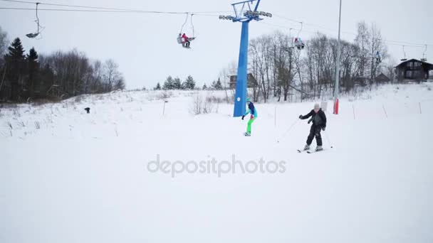 Garçon rapidement vers le bas sur la pente et les promenades de fille en hiver — Video